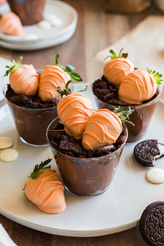 Carrot Patch Dirt Cups feature chocolate covered strawberries, oreos and pudding - perfect dessert cups for garden baby shower desserts + Winnie the Pooh baby shower ideas