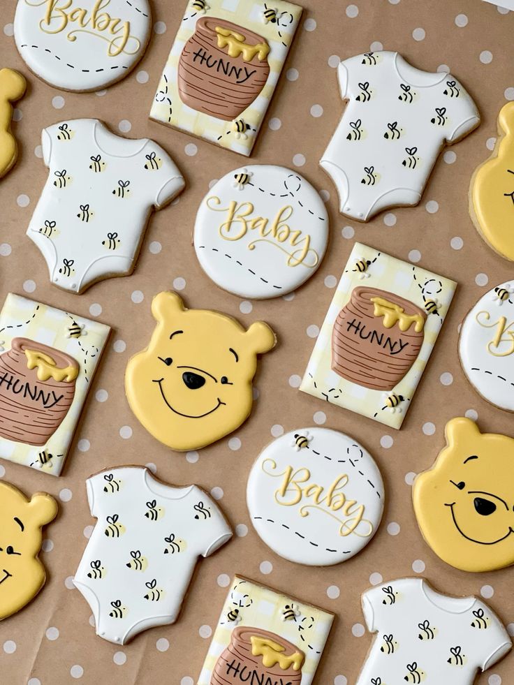 Winnie the Pooh cookies, royal icing cookies featuring Pooh bear, hunny pots, bumble bees, baby onesies for Winnie the Pooh baby shower dessert table